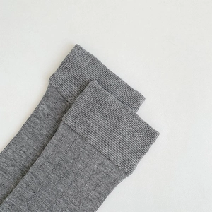 Gros plan de chaussettes gris foncé montrant la texture détaillée des bords-côtes