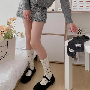 Détail de chaussettes blanches à pois avec étiquette en tissu et chaussures Mary Jane