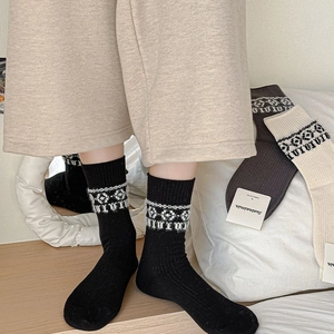 Detail of knit socks with white floral patterns and vertical rib texture in black color