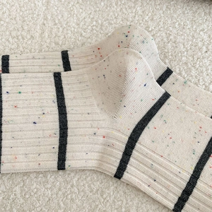 Detailed texture of Japanese style striped socks made of confetti yarn in beige and black