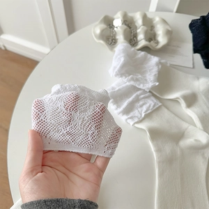 Detailed close-up of cream white lace mesh calf socks with delicate hollowed-out patterns
