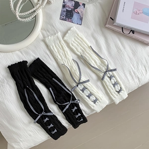 Detail of cable knit leg warmers featuring cross-lace gingham ribbon bows in JK style