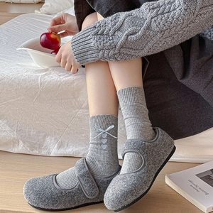 Gray felt Mary Jane shoes with velcro strap and ribbon bow socks in cozy home setting