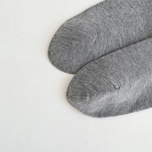 Gros plan sur les chaussettes grises montrant la texture fine et les coutures de pointe