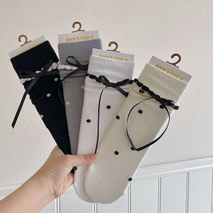 Close-up of four-color knit socks set with black polka dots and delicate ribbon bows