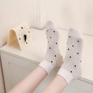 Breathable ribbed cotton mid-calf socks with small black heart patterns in off-white