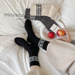 Close-up of three pairs of knit crew socks featuring geometric jacquard patterns on cuffs