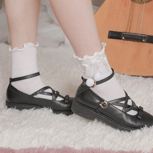 Dettaglio calzini bianchi Lolita con volant, fiocchi e pompon con scarpe Mary Jane