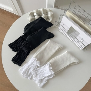 Close-up of ribbed texture and delicate lace trim on black and white calf-length socks