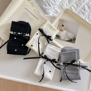 Flat lay of Japanese style knee-high socks featuring silk bows and polka dot patterns