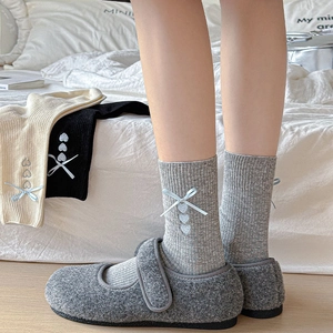 Detail of socks with heart embroidery and blue ribbon paired with Mary Jane shoes