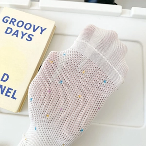 Gros plan détaillé de chaussettes en résille blanche à pois colorés au style minimaliste