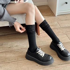 Detail of black lace trim mesh socks with vertical ribbing paired with platform loafers