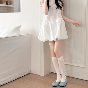 Détail de chaussettes hautes blanches avec texture en tricot et ballerines bleues