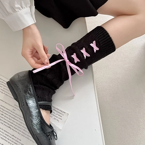 Detail of Lolita knit leg warmers with pink plaid ribbon bows and balletcore style