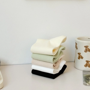 Detail of five assorted colors cotton socks with cute embroidery in a cozy home setting