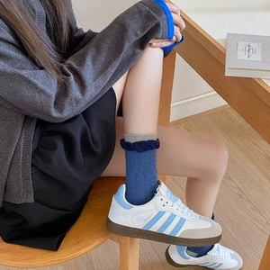 Detail of blue frilly socks with vintage floral texture and grey contrast toe design