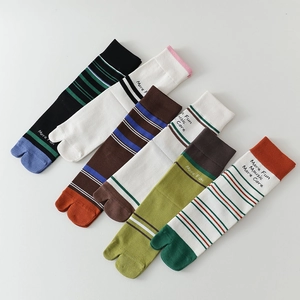 Detail of five striped Tabi socks in various colors with knit texture and slogan prints