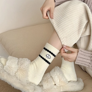 Détail de la broderie chiot sur chaussettes en laine chaude avec rayures noires