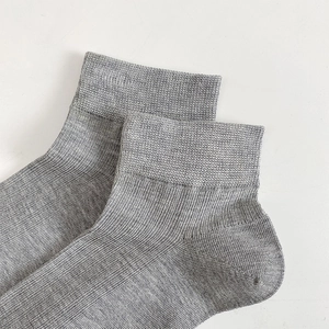 Close-up of gray cotton blend socks showing fine ribbed texture and elastic ankle cuffs