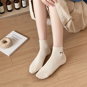 Detailed close-up of beige mesh breathable cotton socks with cute dog embroidery