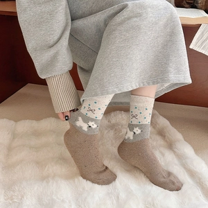 Detail of wool socks featuring dog jacquard and bow patterns on warm fleece carpet