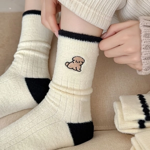Gros plan de chaussettes thermiques en tricot avec broderie chiot et détails noirs