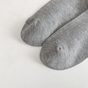 Macro detail of breathable grey mesh knit socks with seamless toe and cotton texture