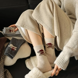 Close-up of soft knitted wool socks featuring cute cartoon dog pattern with red beret