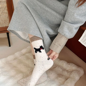 Close-up of knit wool socks with cute terrier dog pattern and velvet bow details