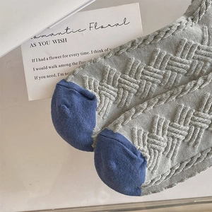 Close-up of thick knitted socks featuring embossed texture and blue contrast heel