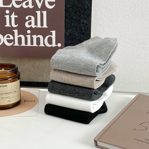 Five pairs of men's breathable cotton mesh socks in neutral colors neatly stacked on a desk