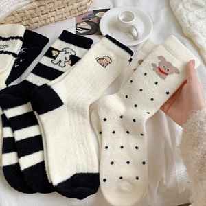 Détail de chaussettes thermiques pelucheuses avec broderies animaux et motifs à pois
