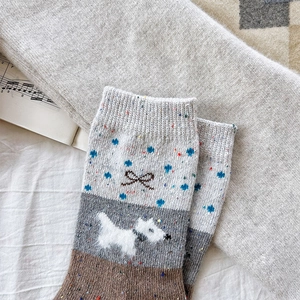 Detail of wool blend socks with embroidery of a small dog and a blue bow design