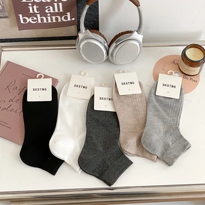 Five pairs of men's low cut mesh socks in assorted solid colors on a white surface