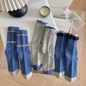 Detailed close-up of three pairs of vintage blue and grey textured cotton crew socks