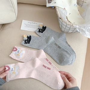 Detail of cute bear socks with animal embroidery and kiki sox knit text in home setting
