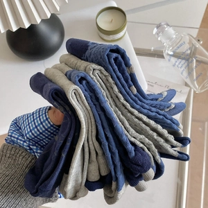 Detail of stacked cotton socks showing rib knit texture in muted blue and grey tones