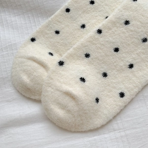 Gros plan de chaussettes thermiques épaisses à pois noirs et texture pelucheuse douce