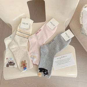 Detail of cotton crew socks featuring cute cartoon bear embroidery and striped patterns