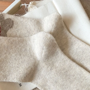 Macro detail of thick wool socks showing knitting texture and cute cartoon puppy pattern