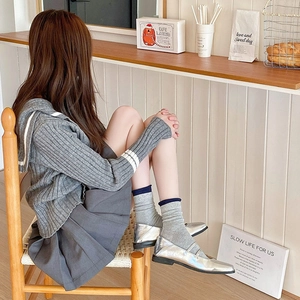 Close-up of Japanese preppy style grey crew socks with blue ruffled lace trim detail