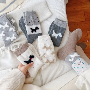 Detailed knit texture of wool socks featuring cute dog patterns and bowknot accents