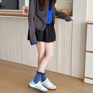 Detail of blue lace socks with embossed wave pattern paired with retro style sneakers