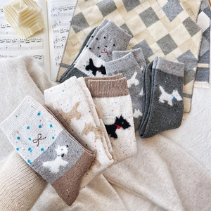Detail of knitted socks with cute Scottish Terrier embroidery and sweet bow accents