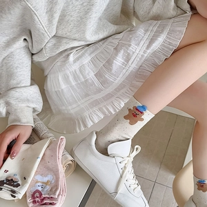 Detail showing cute bear embroidery on beige and pink cotton mid-calf socks