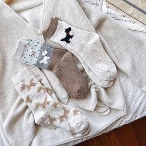 Flat lay of vintage nep yarn wool socks with cute puppy patterns and bow details