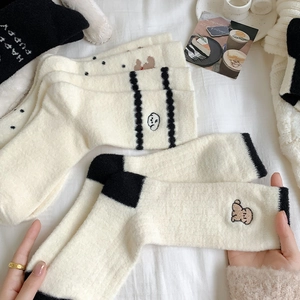 Détail de chaussettes douillettes avec broderie de chiot et rayures noires