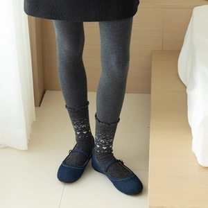 Detail of grey wool socks with heart and bow patterns worn with blue Mary Jane shoes