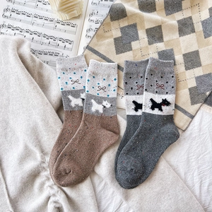 Detail of wool knit socks featuring cute puppy jacquard and colorful dotted texture